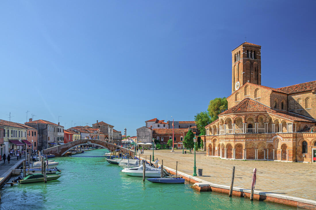 Čluny zaparkované na kanálu Benátského ostrova Murano, napravo kostel Santa Maria e San Donato se zvonicí